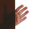 Na zdjęciu widać lamelę spawalniczą w kolorze brązowym, która częściowo przepuszcza światło. Po drugiej stronie lameli widać rękę.